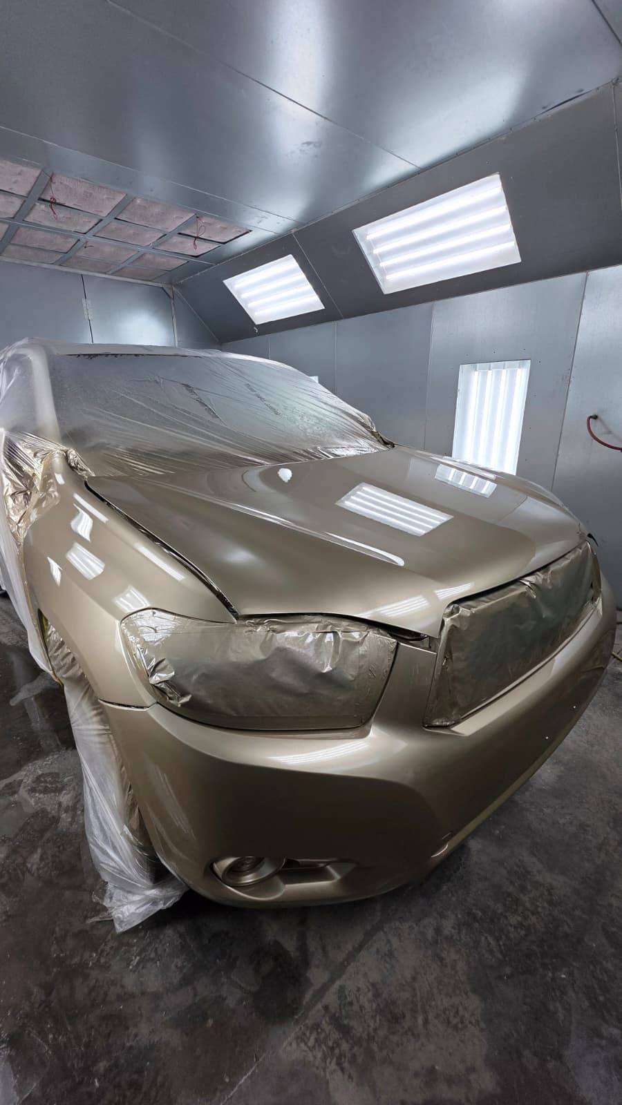 Gold SUV masked and prepped in paint booth