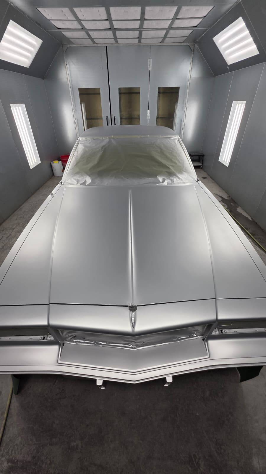 Silver classic car front overhead in paint booth