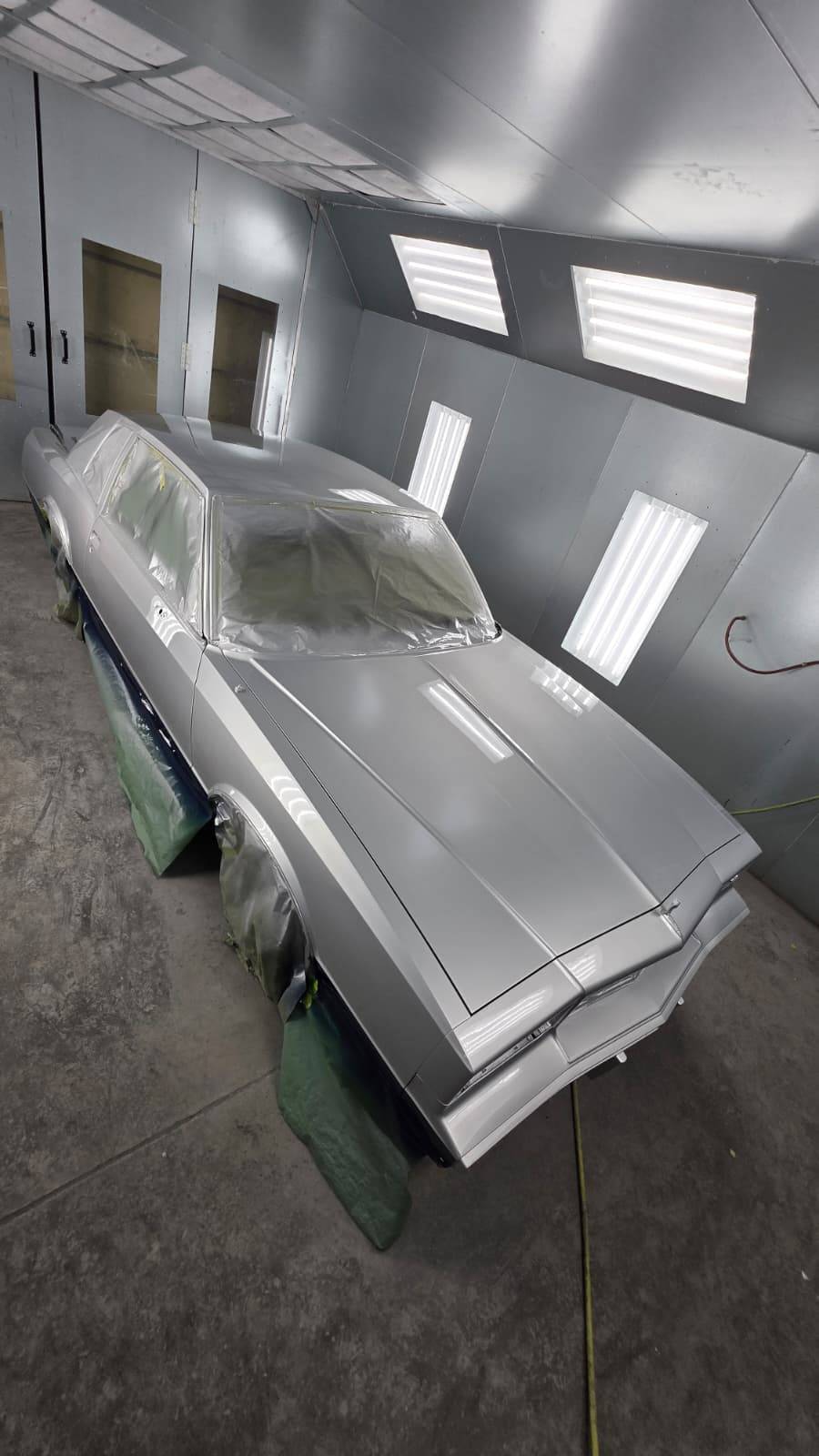 Silver classic car side angle in paint booth — CarTech Automotive
