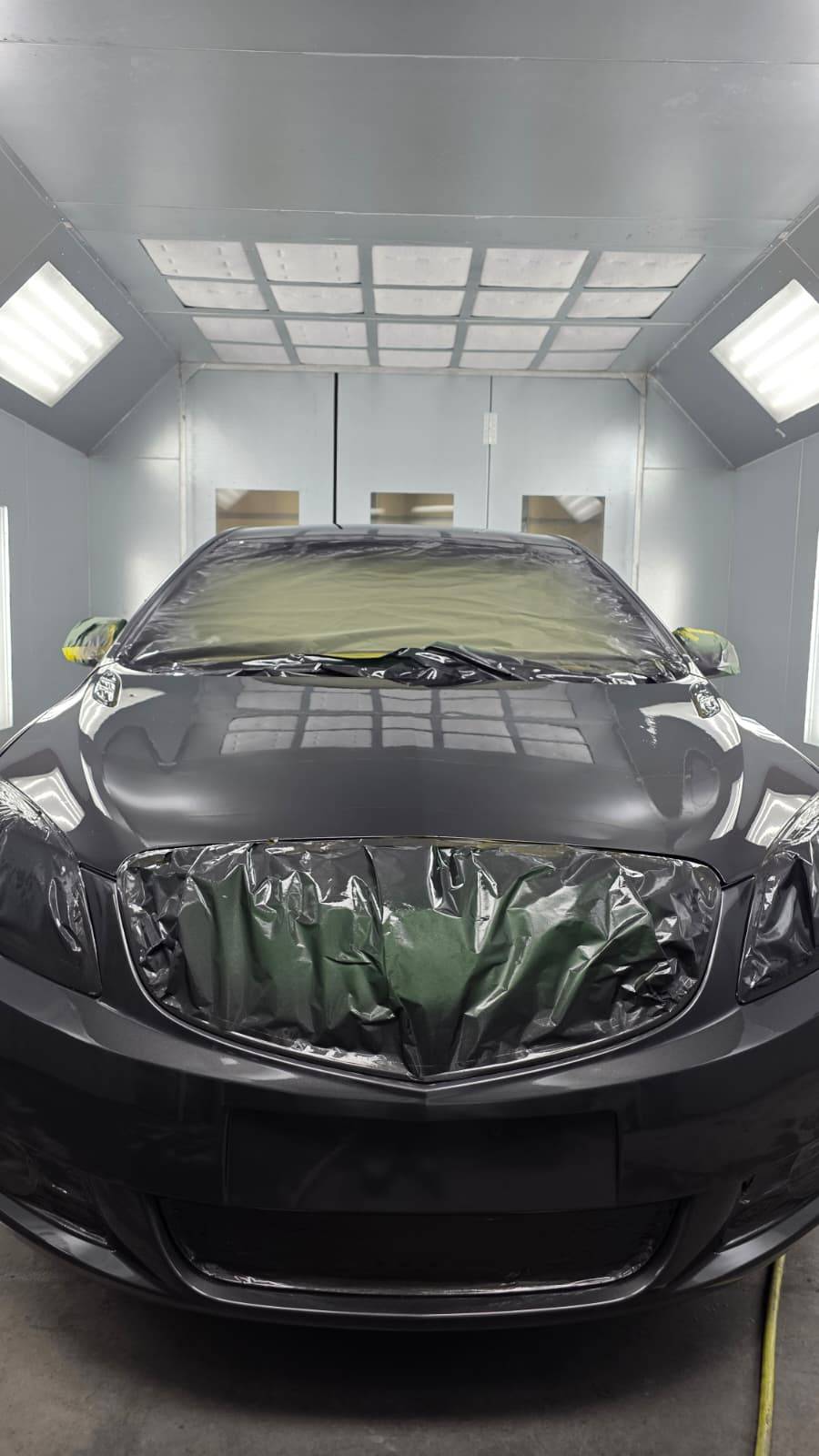 Black car centered in paint booth — CarTech Automotive